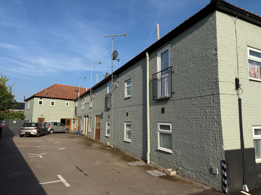 Lot: 194 - VACANT FREEHOLD TOWNHOUSE WITH PARKING - View of the parking forecourt and townhouse complex